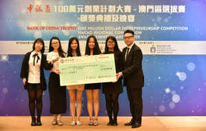 2:binary?id=6_2FkVYm06A1fN0fSppgLZFSd700COSNlyFz3p5bihLMlmXzkSILB8P_2ByBMpBzXdFK:A representative of the Macao Economic Services presents the second prize to the winning team